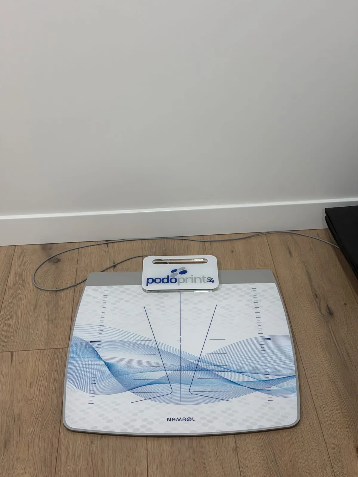 Plataforma de presiones Podoprint en el suelo de la consulta, para el estudio biomecánico de la pisada. Clínica Paula Vega, Leganés