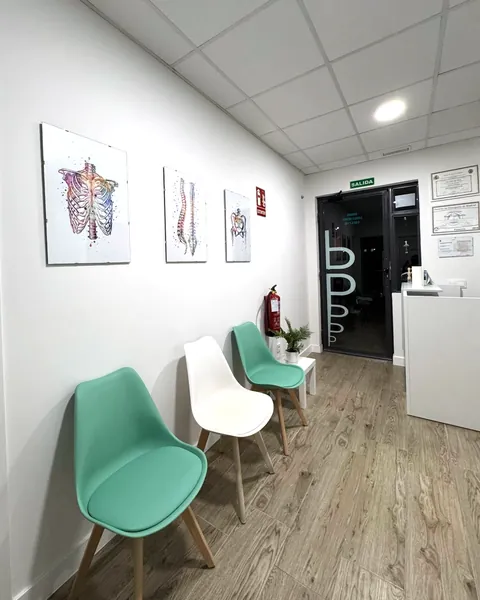 Recepción y puerta de entrada de la Clínica Paula Vega, con los diplomas de osteopatía en la pared