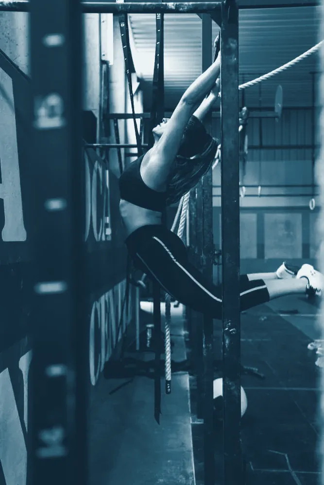 Deportista colgado de unas anillas de gimnasia en un box de entrenamiento