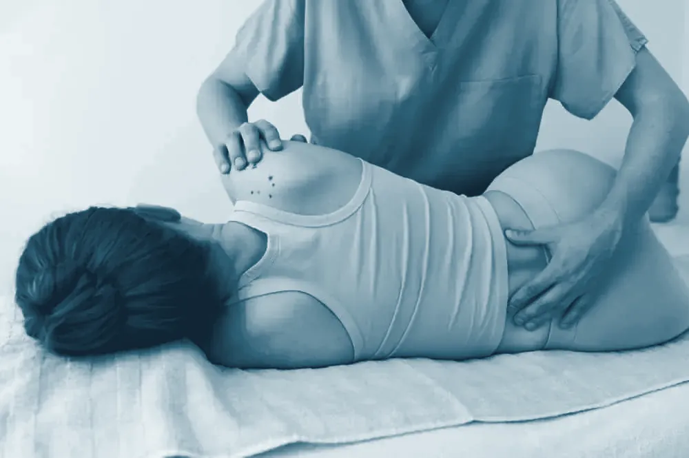 Fisioterapeuta osteópata aplicando una técnica manual en la zona lumbar