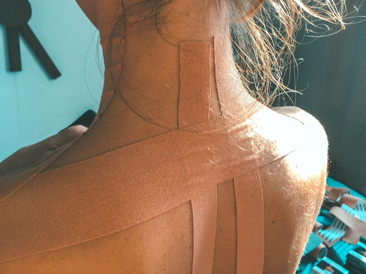 Vendaje neuromuscular con tiras de kinesiotape en el cuello y la parte alta de la espalda de una deportista